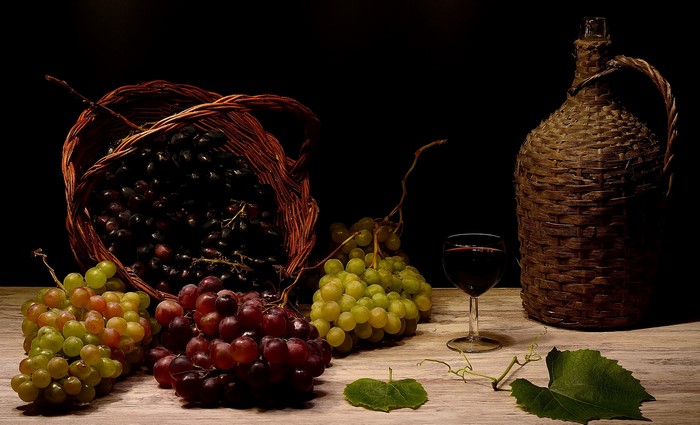 Still life of grapes, wine, and a wicker jug