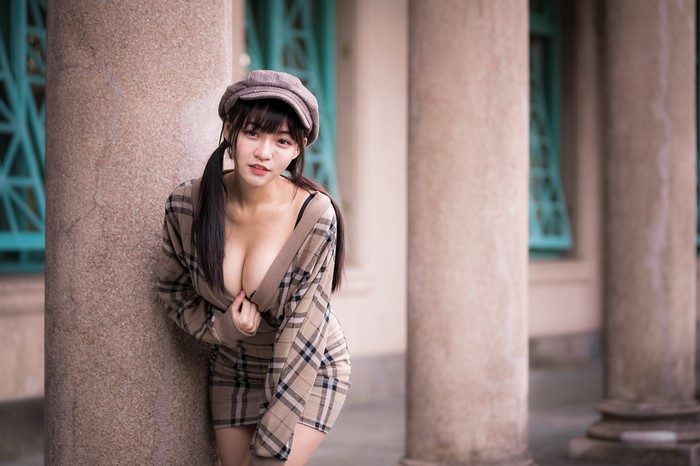 Asian woman in plaid dress and baseball cap
