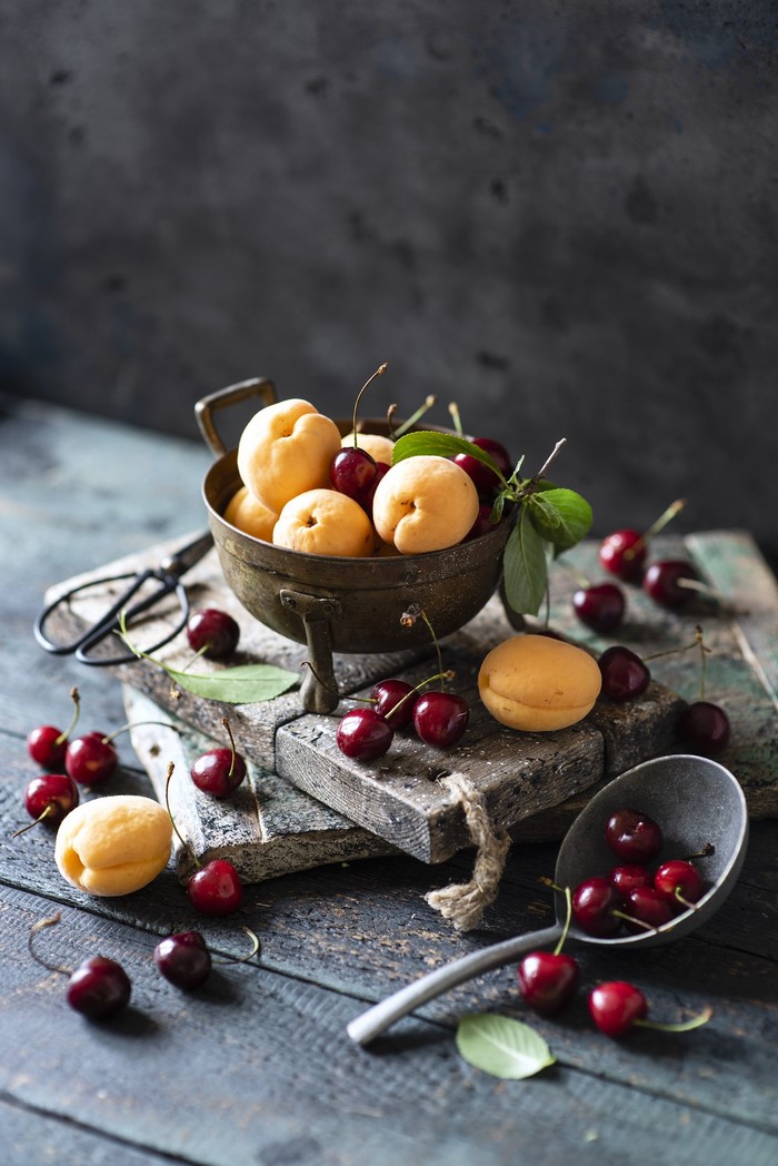 Cherries and apricots in a bowl and spoon
