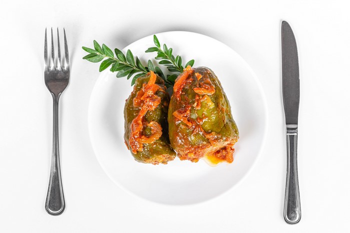 Stuffed Bell Peppers on a Plate with Fork and Knife
