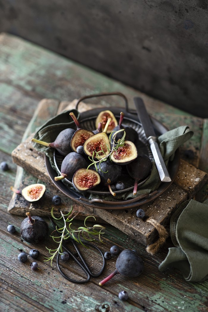 Figs and blueberries on wooden planks with knife