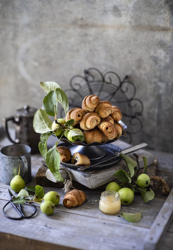 Croissants with apples and honey on a wooden table