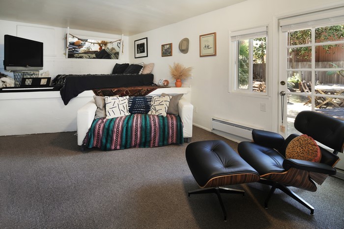 Living room with sofa, armchair, and bed