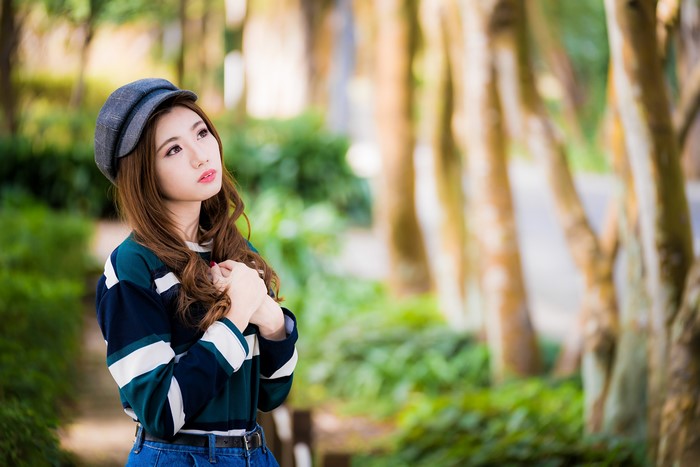 Asian woman wearing a baseball cap and striped shirt