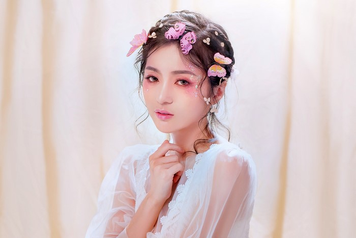 Asian woman with butterfly hair accessories and makeup