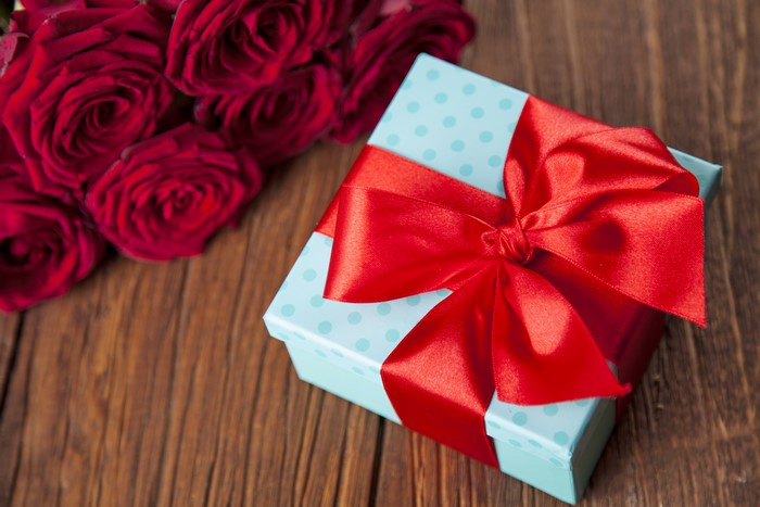 Red roses and a gift box with a red bow