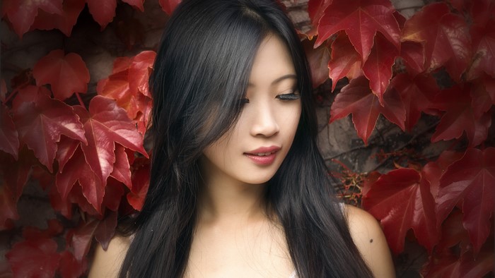 Asian woman with dark hair and red foliage
