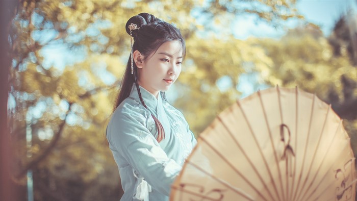 Asian woman in traditional Chinese clothing with umbrella