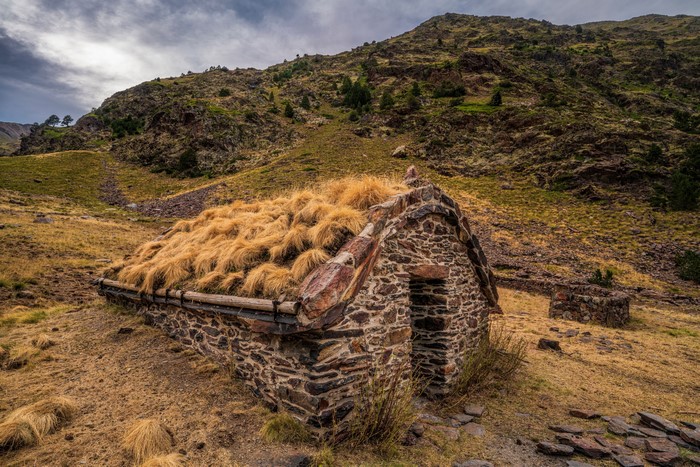 Stone hut with grass roof in Coma Pedrosa National Park, Andorra