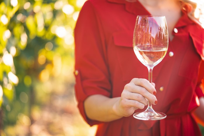 Woman in red dress holding a glass of white wine