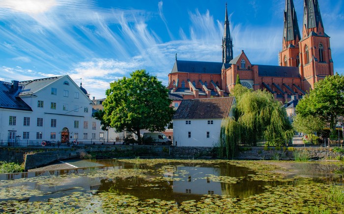 Uppsala Cathedral and houses by a pond in Sweden