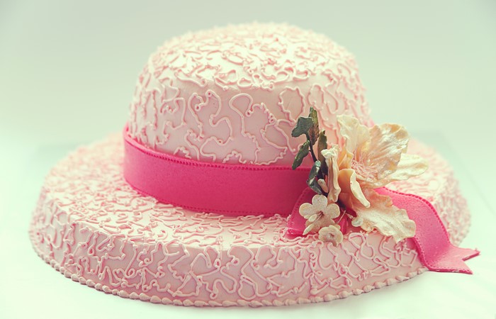 Pink hat cake with ribbon and flowers