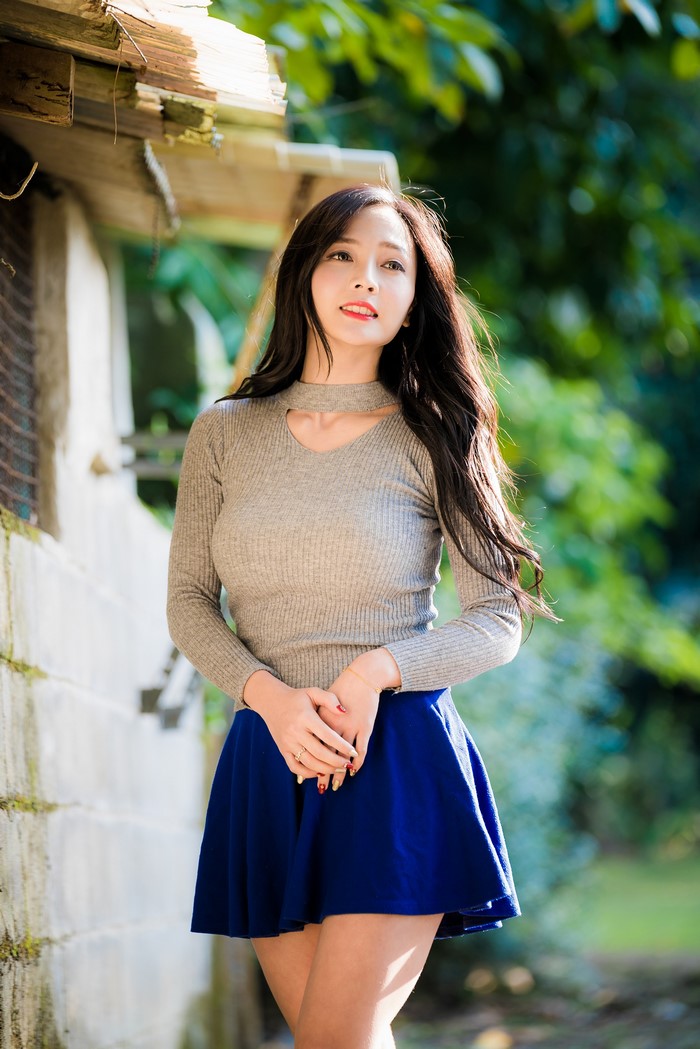 Asian Woman in Blue Skirt and Gray Blouse
