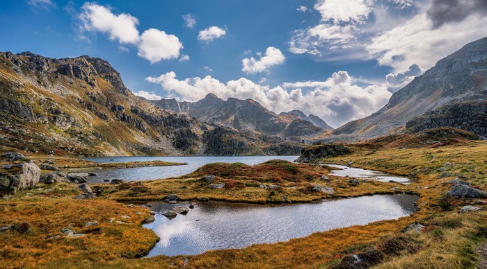 Autumnal Pyrenees Mountains with Lake and Clouds