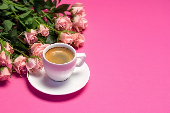 Cup of Coffee with Pink Roses on Pink Background