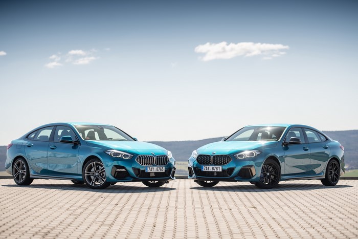 Two light blue BMW coupes parked outdoors