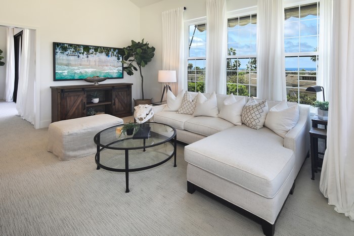 Living room with sofa, TV, and ocean view