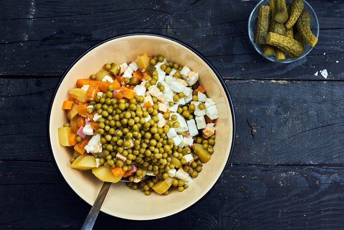 Olivier salad with peas, potatoes, carrots, eggs, and pickles