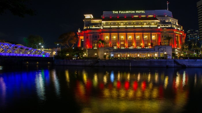 The Fullerton Hotel and bridge at night in Singapore