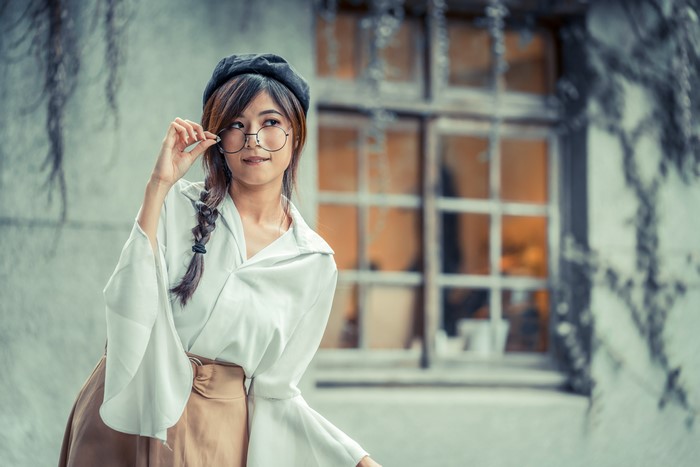 Asian woman with braid hair wearing beret and glasses