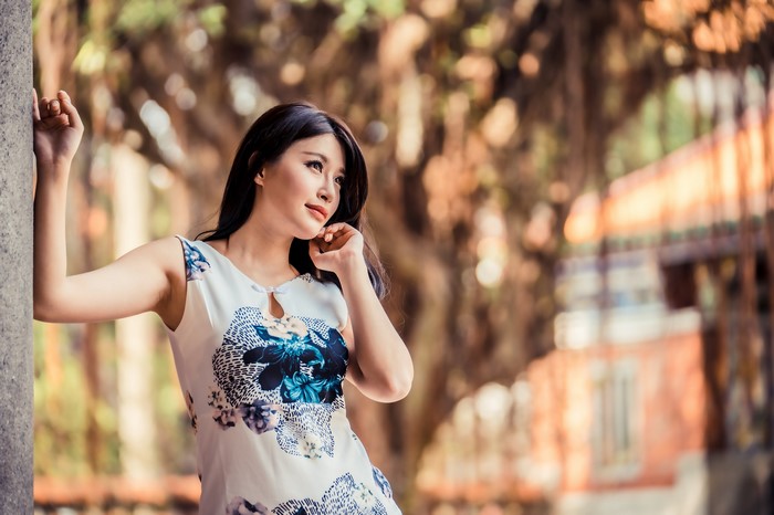 Asian woman in floral dress posing outdoors