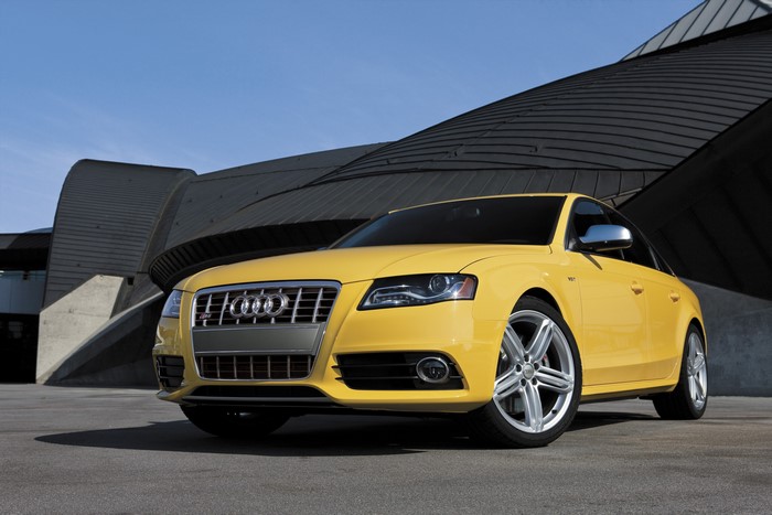 Yellow Audi S4 Sedan parked in front of modern architecture