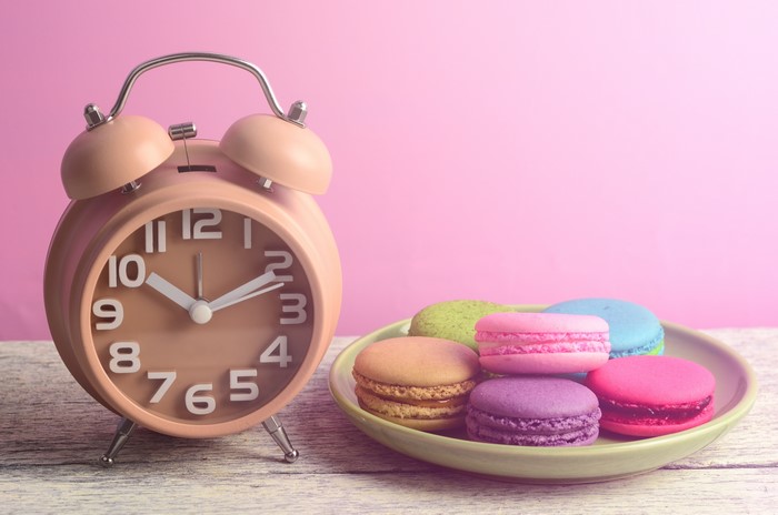 Alarm clock and macarons on a table