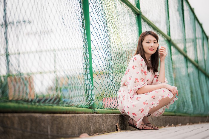 4K Asian Woman Sitting by Fence in Floral Dress