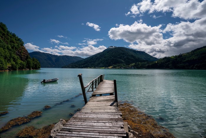 Wooden pier on Lustrafjorden, Norway with mountains and clouds
