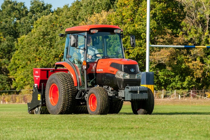 Kubota L2501 tractor with aerator attachment on a field