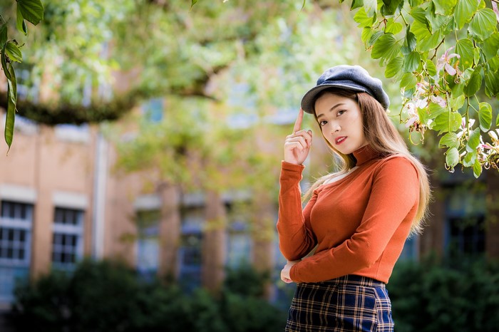 Asian woman in sweater and baseball cap