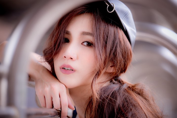 Asian woman with brown hair wearing a black cap
