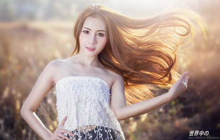 Asian Woman with Flowing Brown Hair Posing Outdoors