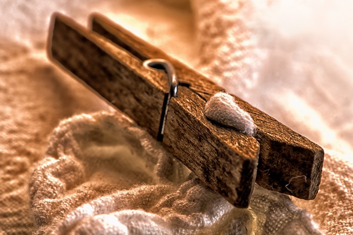 Wooden clothespin on textured fabric