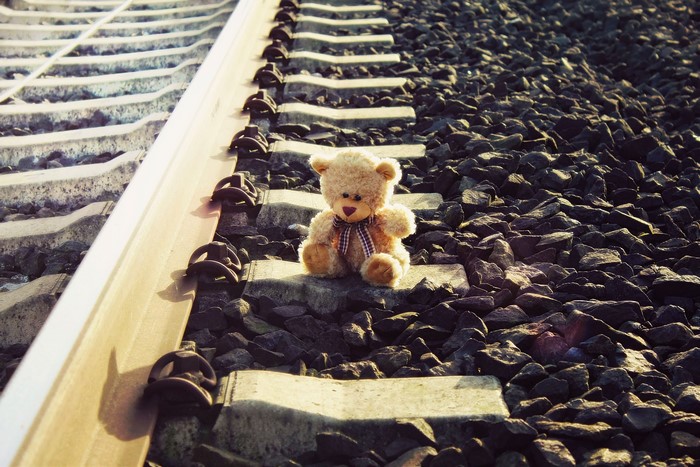 4K Teddy bear on railroad tracks