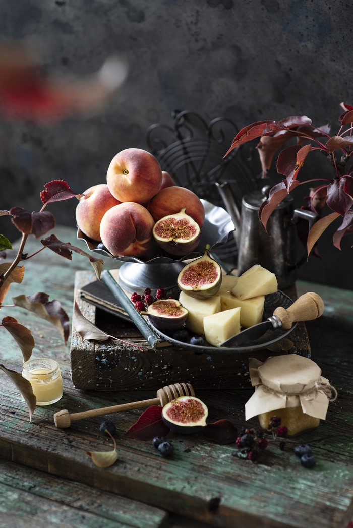 Still life with peaches, figs, cheese, and honey
