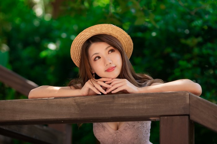 Asian woman wearing a straw hat and dress