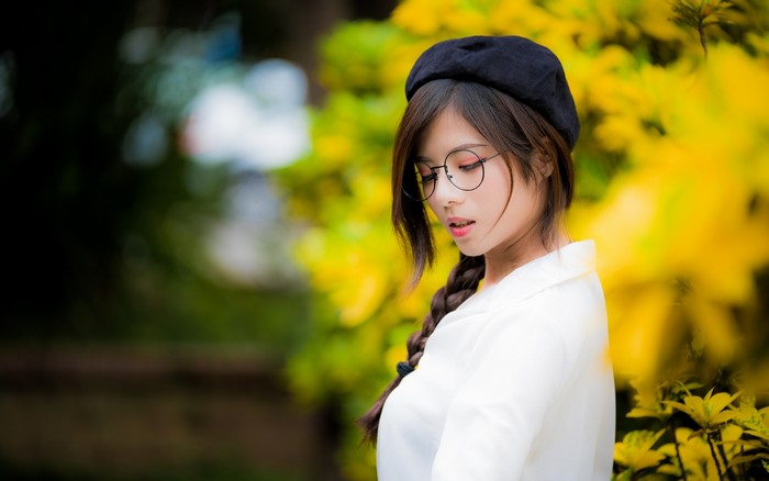 Asian girl with glasses and beret in yellow flowers
