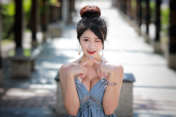 Asian woman with hands on cheeks winking