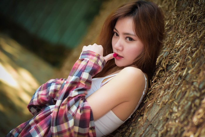 Asian woman with brown hair wearing plaid shirt