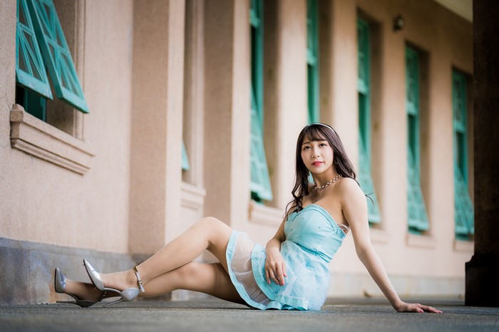 Asian woman in a blue dress sitting outdoors