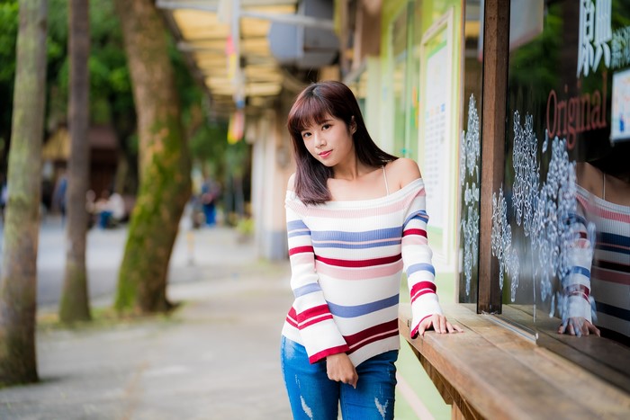 Asian woman with brown hair wearing a striped sweater