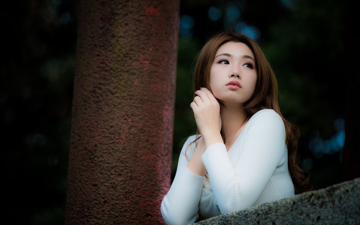 Asian woman with brown hair looking away