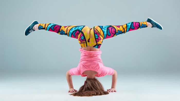 Girl doing a handstand in colorful leggings
