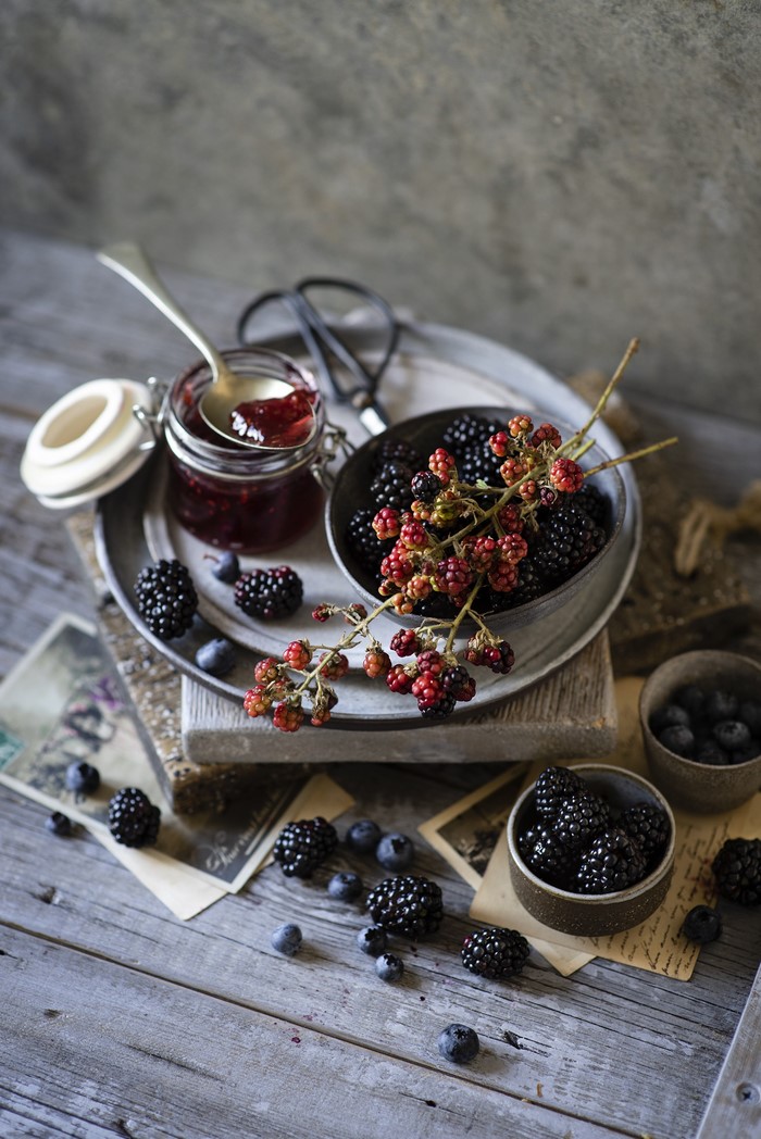 Blackberries and blueberries with jam on wooden planks