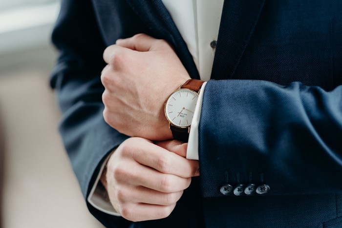Man in Suit Adjusting Watch