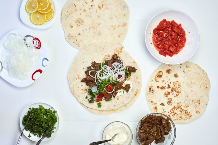 Shawarma ingredients with flatbreads and lemons