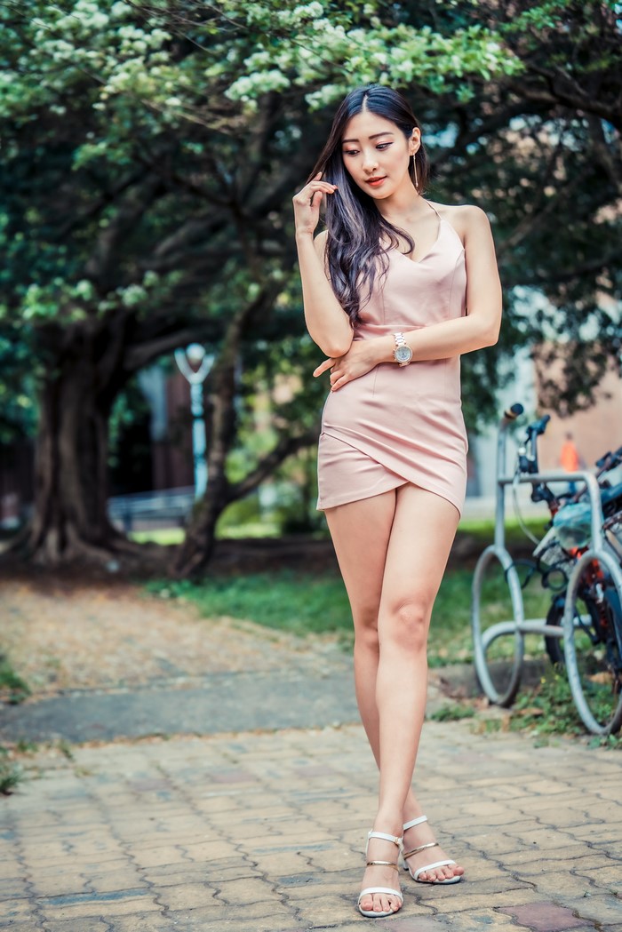 Asian woman in pink dress posing outdoors