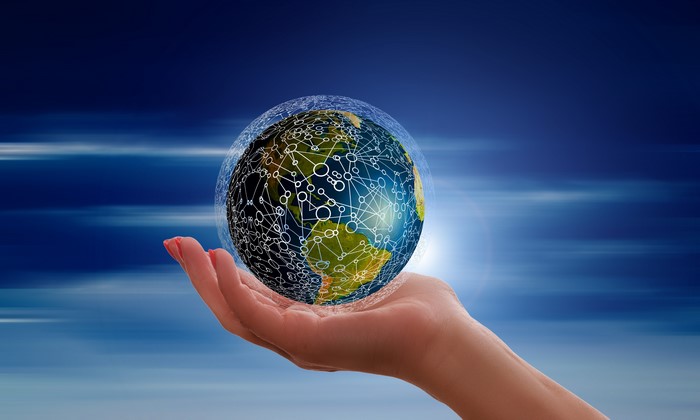Hand holding Earth with network connections