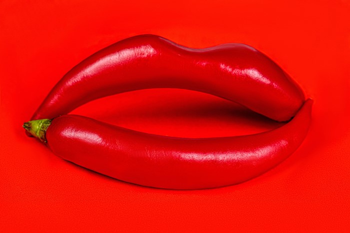 Red Lips Made of Chili Peppers on Red Background